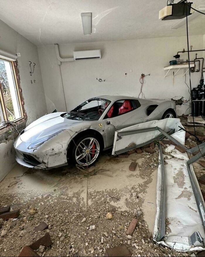 Damaged sports car in a garage, indicating an unfortunate incident likely costing a fortune.