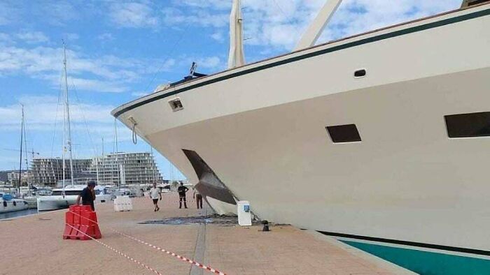 Yacht crashed into dock with onlookers, illustrating an expensive incident likely costing a fortune.