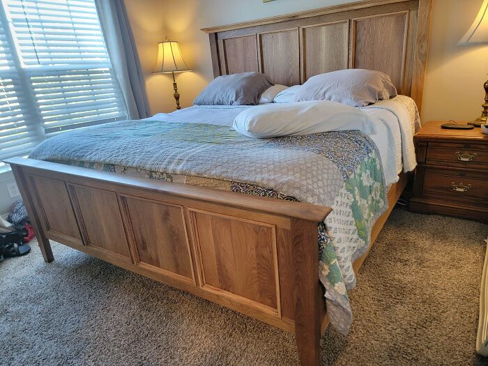 Woodworking project showcasing a handcrafted wooden bedframe in a cozy bedroom setting.