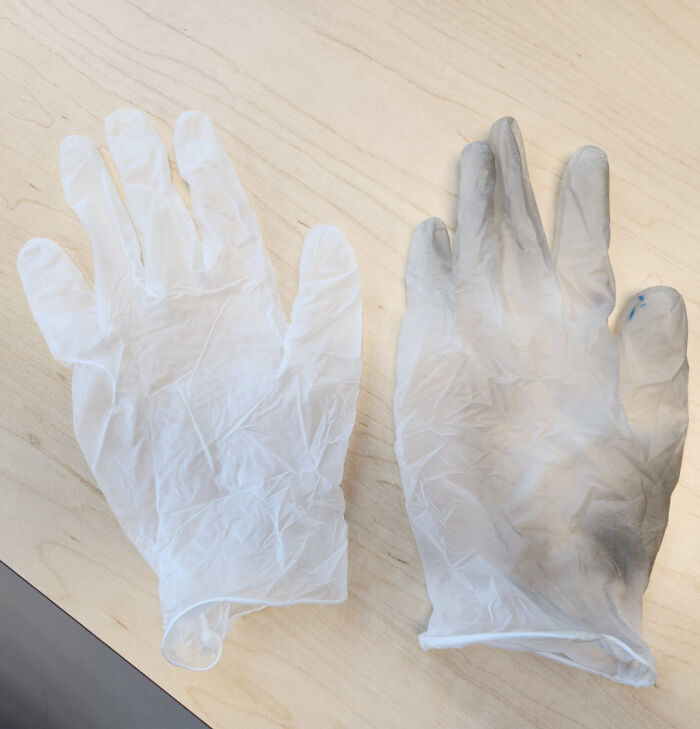 Two gloves on a table, one clean and one dirty, showcasing a mildly interesting contrast.