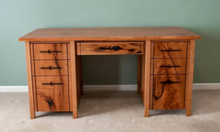 Woodworking project featuring a handcrafted wooden desk with six drawers and natural wood grain details.