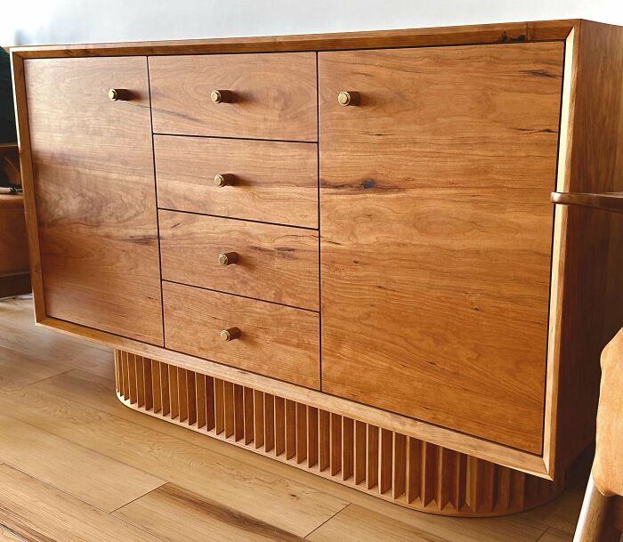 Woodworking project showcasing a wooden cabinet with drawers and brass knobs, highlighting fine craftsmanship.