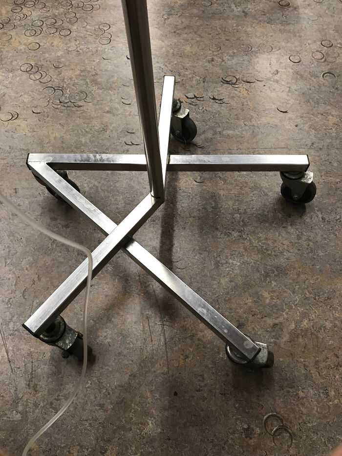 A metal chair leg leaves crescent-shaped marks on a tiled floor, creating a mildly interesting pattern.