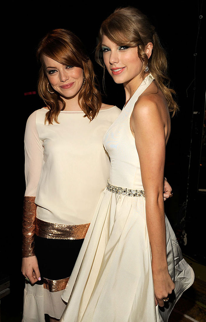 Taylor Swift in a white dress standing beside a Emma Stone in a beige top with metallic accents, both smiling. How tall is Taylor Swift?