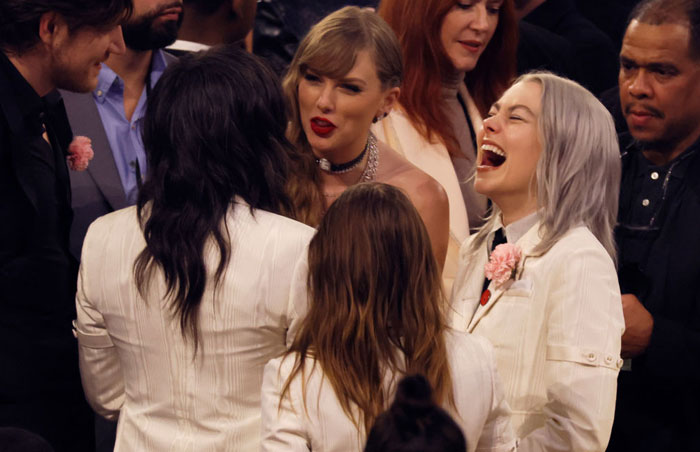 Taylor Swift talking with Julien Baker, Phoebe Bridgers, and Lucy Dacus at a social event, with Phoebe Bridgers laughing. How tall is Taylor Swift?