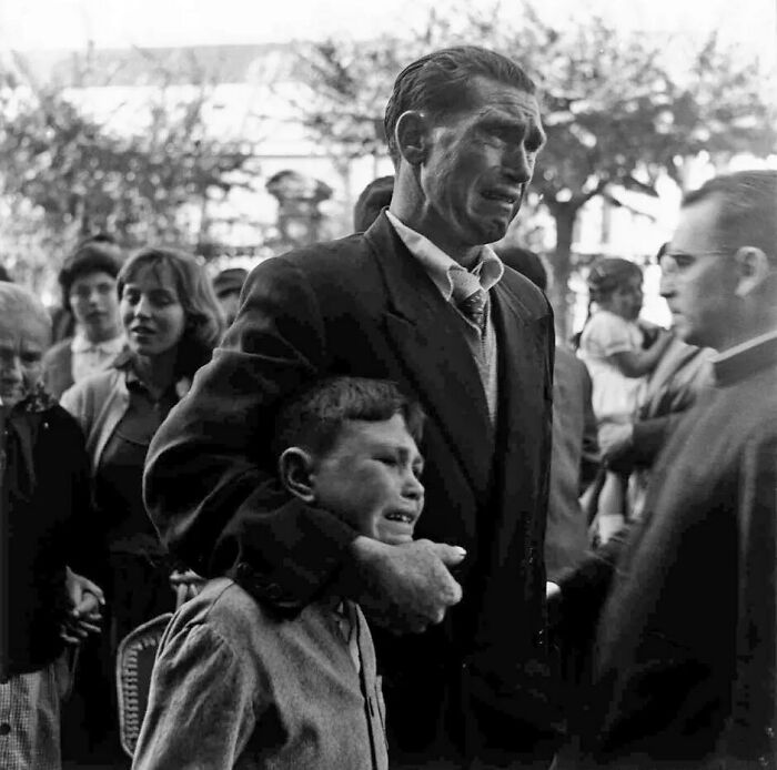 Padre e hijo llorando al despedirse de sus familiares que embarcan hacia Buenos Aires en busca de una vida mejor durante la penuria económica en España. El fotógrafo Manuel Ferrol tomó esta fotografía en 1957 en el puerto de A Coruña.