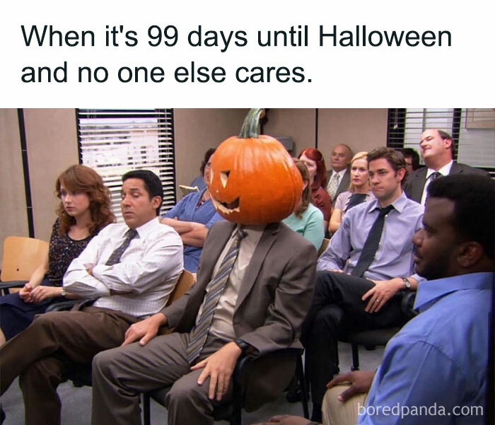 A Fall meme with a person wearing a carved pumpkin head in an office meeting. The text reads, "When it's 99 days until Halloween and no one else cares," highlighting their enthusiasm.