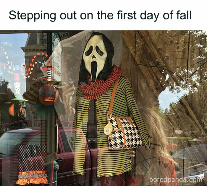 A Fall meme with a mannequin wearing a striped outfit, scarf, and a spooky mask in a shop window. The text reads, "Stepping out on the first day of fall," humorously capturing the excitement of embracing the autumn season.