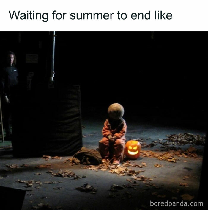 A Fall meme with a person in a spooky costume sitting in the dark next to a glowing jack-o-lantern. The text above reads, "Waiting for summer to end like," humorously depicting the anticipation for the fall season.