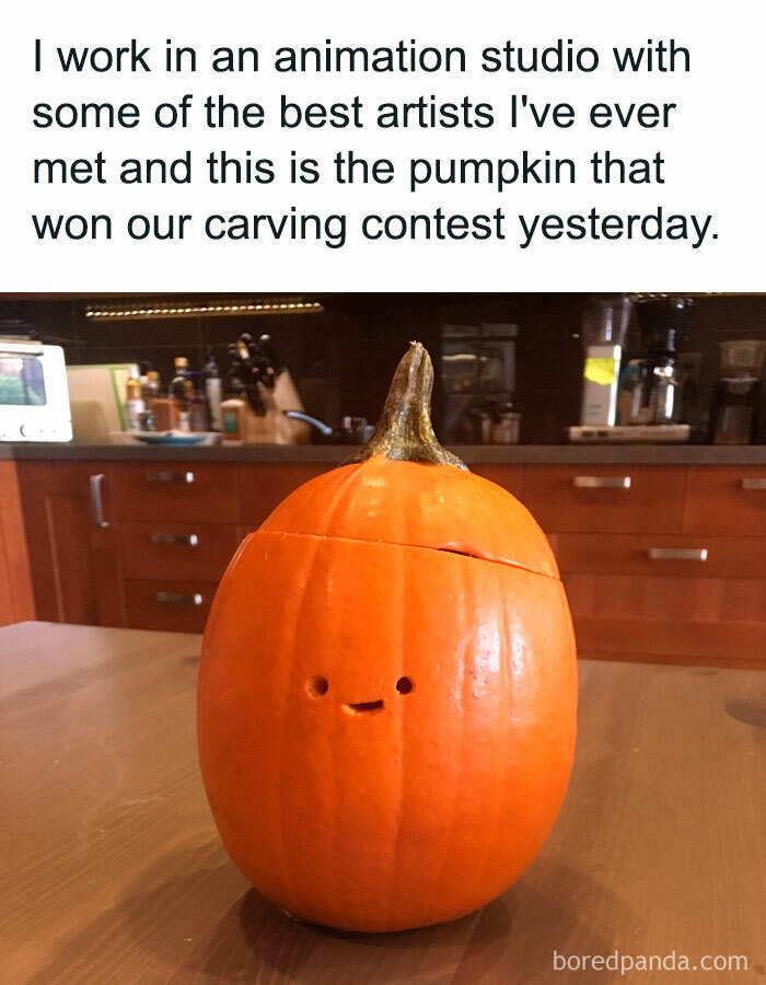  A Halloween meme featuring a simple pumpkin with two small round eyes and a small mouth carved into it. The caption above reads, "I work in an animation studio with some of the best artists I've ever met and this is the pumpkin that won our carving contest yesterday," humorously showcasing the minimalist pumpkin carving.