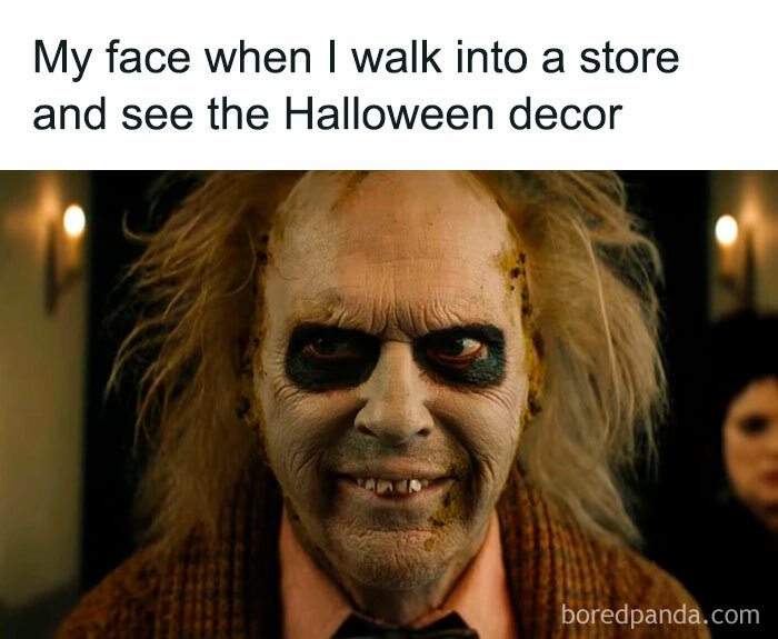 A Halloween meme featuring a close-up image of a character with disheveled hair, dark eyeshadow, and a creepy grin, excitedly looking ahead. The caption above reads, "My face when I walk into a store and see the Halloween decor," humorously expressing the joy of seeing Halloween decorations in stores.