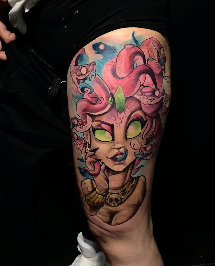  A vibrant Medusa tattoo on the thigh, featuring a playful and colorful design with glowing green eyes, pink snakes in her hair, and a detailed skull necklace.