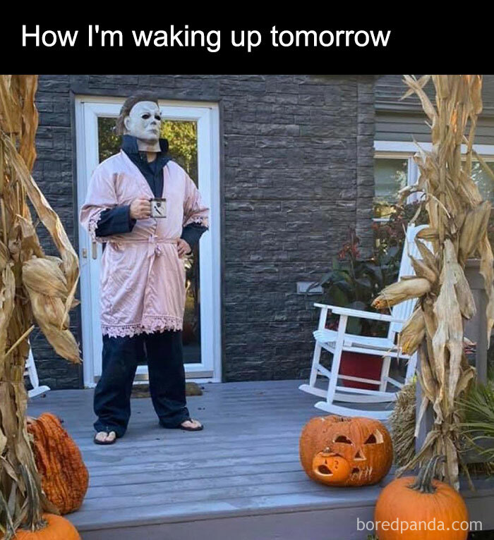 An October meme featuring a character in a scary mask wearing a pink robe, holding a coffee mug on a porch with pumpkins. Text above reads, "How I'm waking up tomorrow," capturing the Halloween spirit.