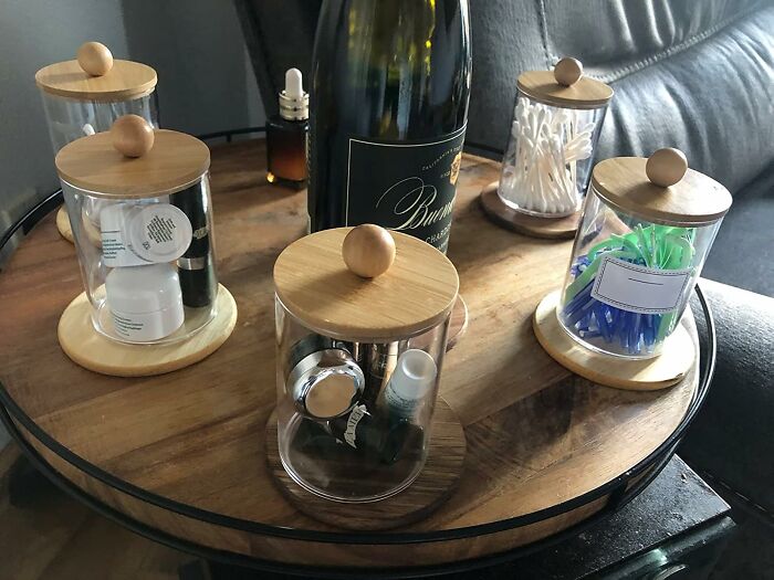 Glass jars on a wooden tray, creatively storing bathroom essentials as cheap fixes for organizational problems.