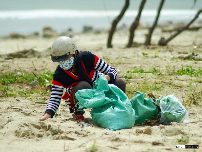 A Woman Is Collecting Sand On The Beach