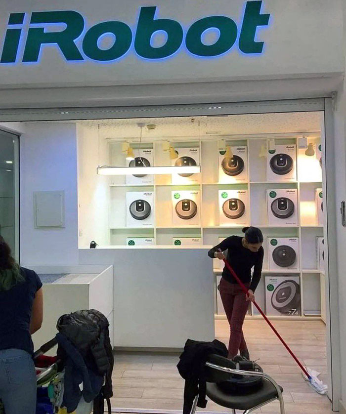 Empleada limpiando el suelo de una tienda de robots aspiradores