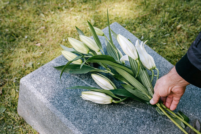 Flowers placed on a grave, symbolizing inheritance and family conflict over sharing wealth.