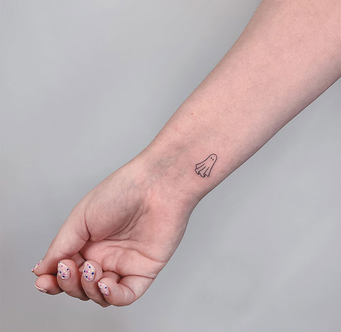 "A small tattoo idea featuring a simple line-drawn ghost on the inner wrist, adding a playful and minimalistic touch."