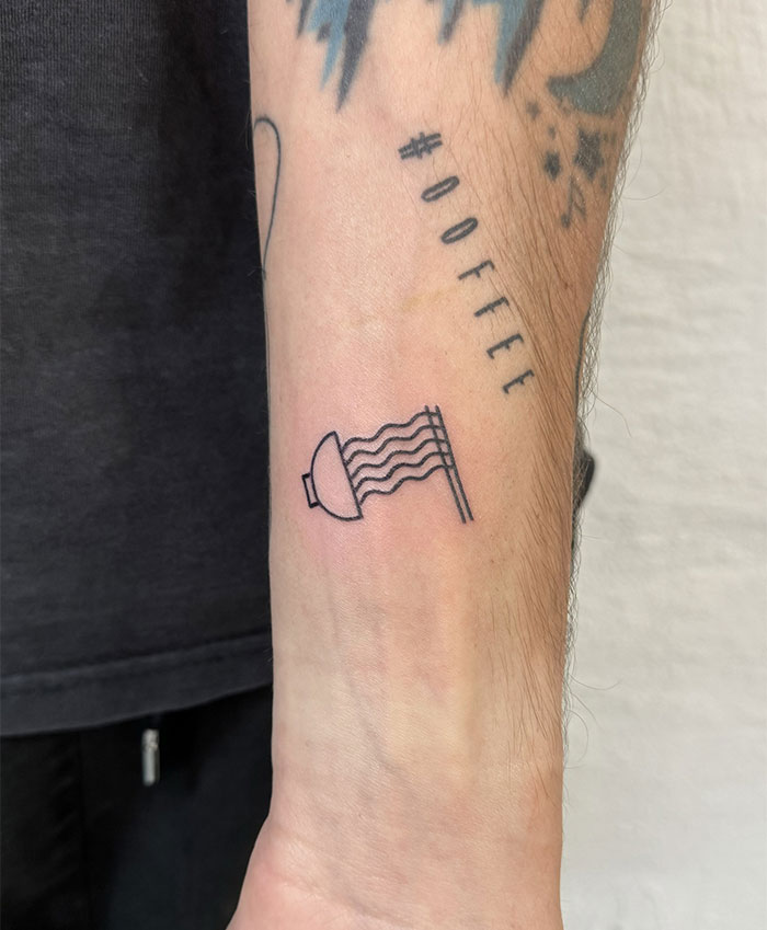 "A small tattoo idea featuring a minimalist line drawing of a shower head with water flowing, placed on the forearm for a quirky design."