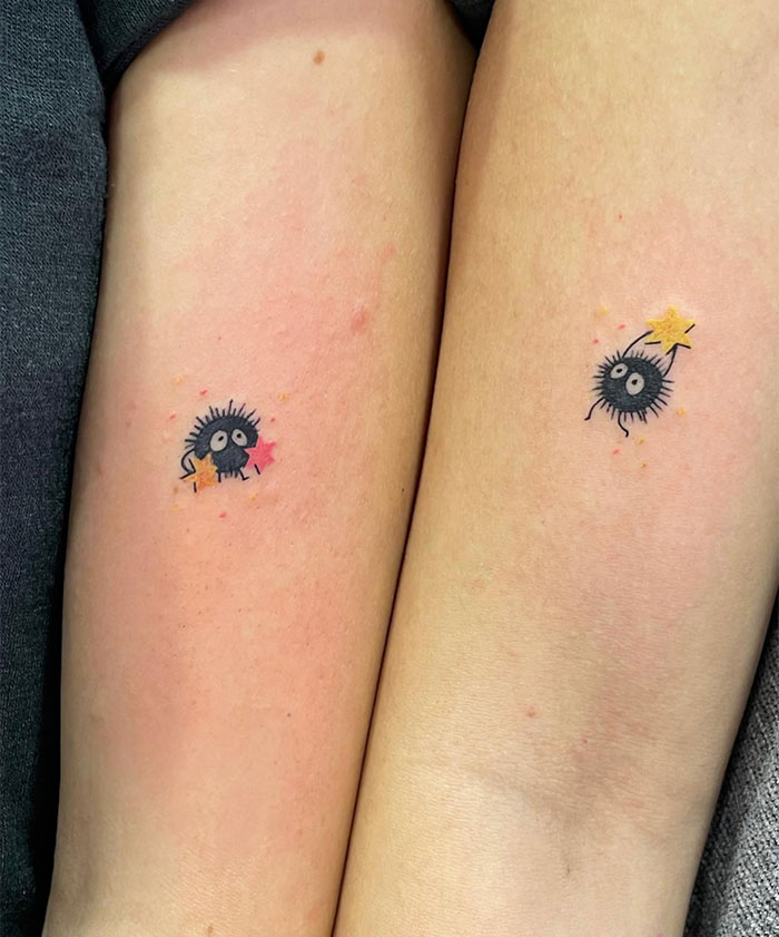 "A small tattoo idea featuring matching soot sprite characters holding colorful stars, symbolizing friendship or shared love for animated films."