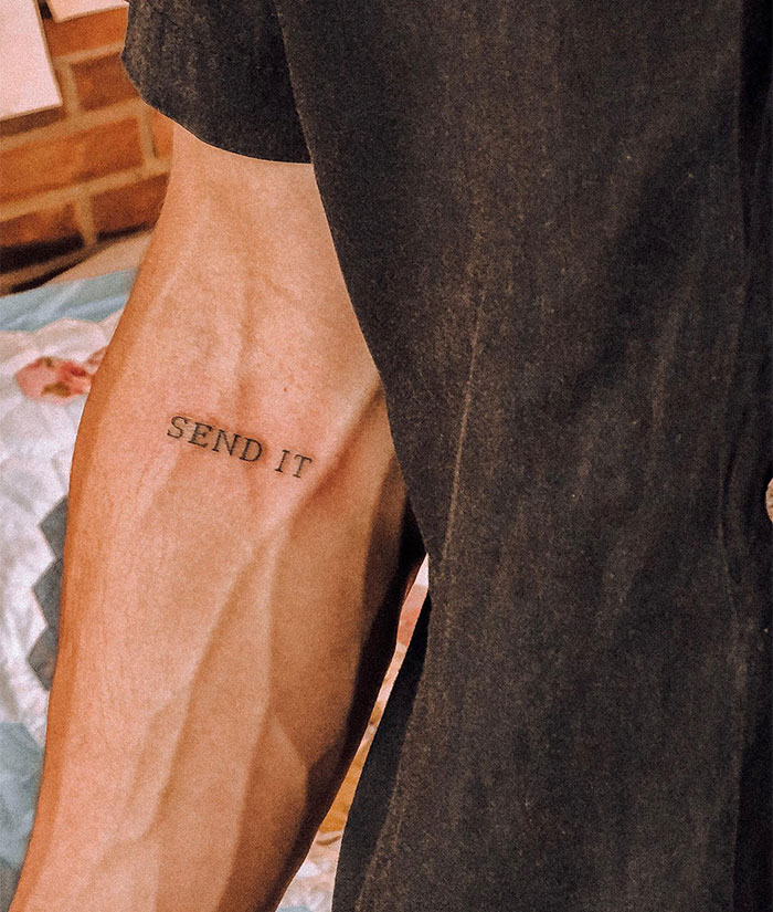 A small tattoo idea with the words "SEND IT" inked in simple font on the inner forearm.