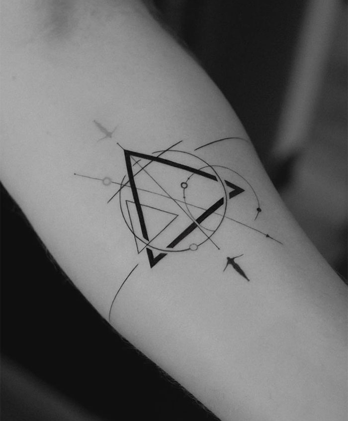 A small tattoo idea featuring an intricate geometric design with overlapping triangles, circles, and precise lines on the forearm, creating a mystical symbol.