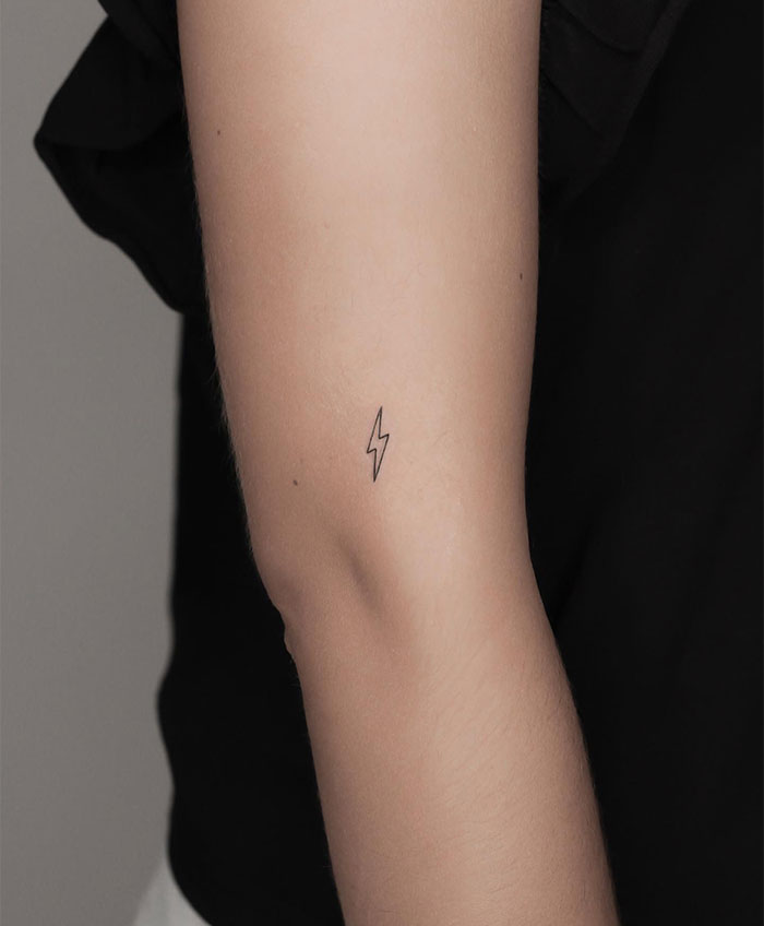 A small tattoo idea featuring a minimalist lightning bolt on the arm, representing power, energy, and inspiration.