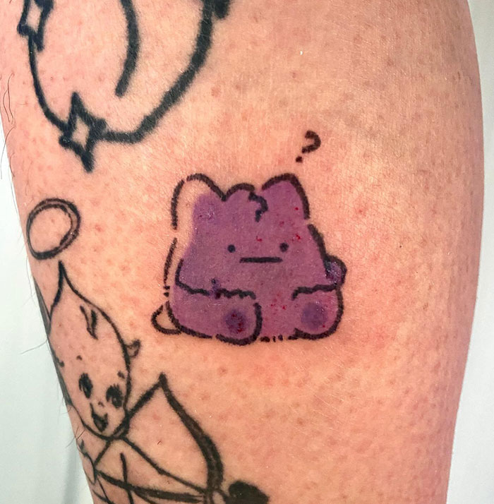 A small tattoo featuring Ditto with a confused expression, adding a touch of humor and personality to the design.