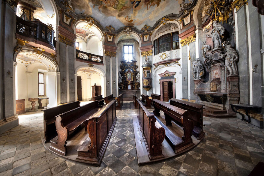 Beautiful abandoned European church interior with wooden pews and ornate decor.