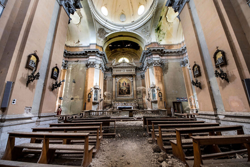 Abandoned sacred church interior in Europe with damaged benches and peeling walls.