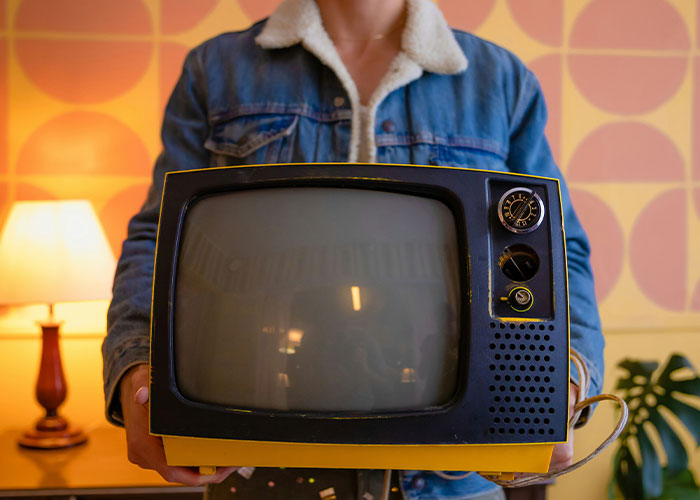 A person holding a vintage TV, showcasing intriguing facts from the "Today I Learned" community.