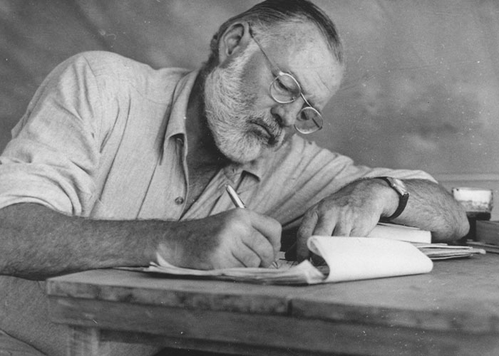 A bearded man in glasses writing at a desk, illustrating intriguing facts from the “Today I Learned” community.