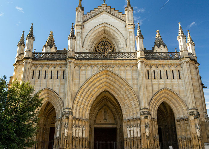 Gothic cathedral facade with intricate arches under a clear sky, showcasing intriguing architectural facts.