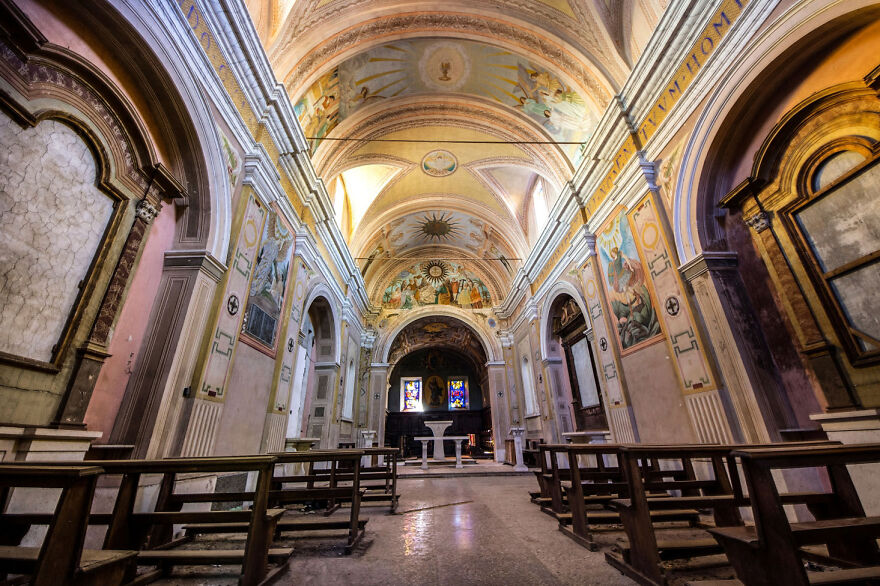 Beautiful abandoned sacred place in Europe with ornate arches, stained glass, and empty pews.