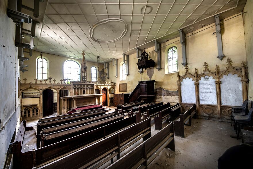 Abandoned sacred place in Europe, featuring an empty, decaying church interior with wooden pews and an ornate altar.