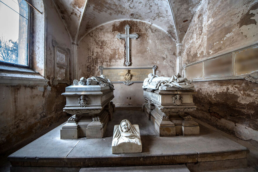 Abandoned sacred place in Europe with ornate stone tombs and weathered walls, creating a serene, historical atmosphere.