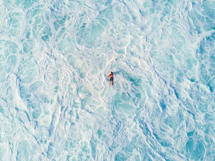 A swimmer amidst ocean waves captures breathtaking sustainability in photography.