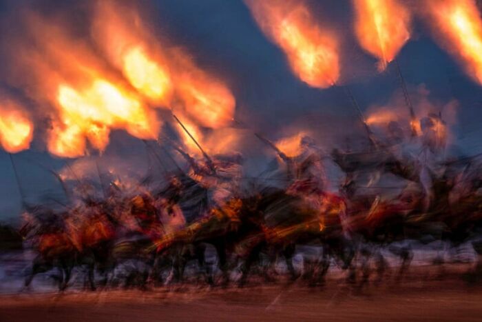 Breathtaking photography with blurred horsemen holding fiery torches, highlighting sustainability themes.