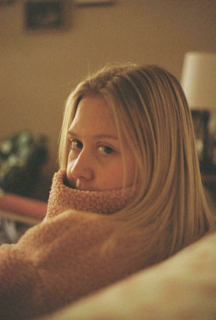 Portrait of a woman with a cozy sweater, resembling Renaissance paintings in warm lighting.