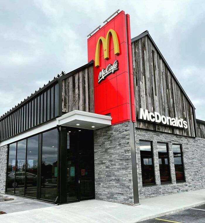 Modern McDonald's in a rustic building conversion, highlighting architectural transformation with red signage.