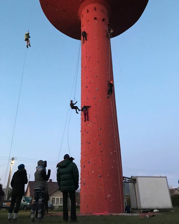 Climbers scale a converted building turned climbing wall, highlighting best building conversions.