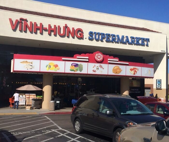 Vinh Hưng Supermarket in a building conversion, featuring diverse food illustrations above the entrance.