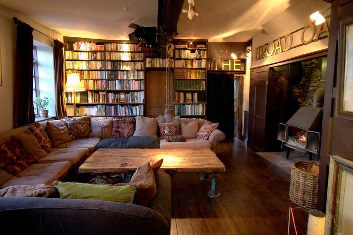 Cozy library with a large sofa and fireplace in a transformed building conversion.