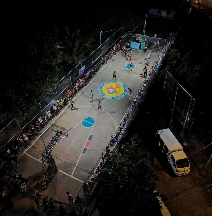 Aerial view of a converted basketball court packed with spectators at night.