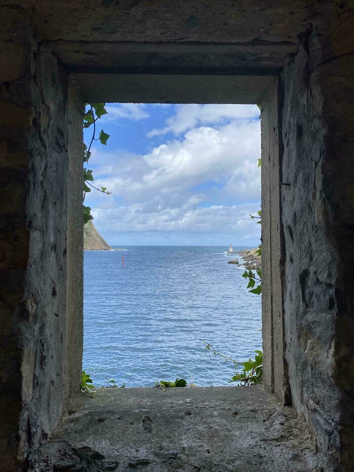 A seascape view through a stone window resembles a Renaissance painting.