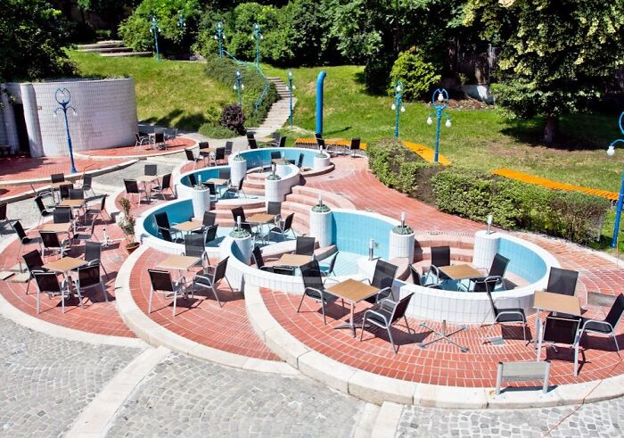 Outdoor dining area with modern design, showcasing a creative building conversion with chairs and tables in a spiral layout.