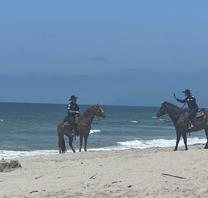 Mounted Police Taking Pictures At The Beach