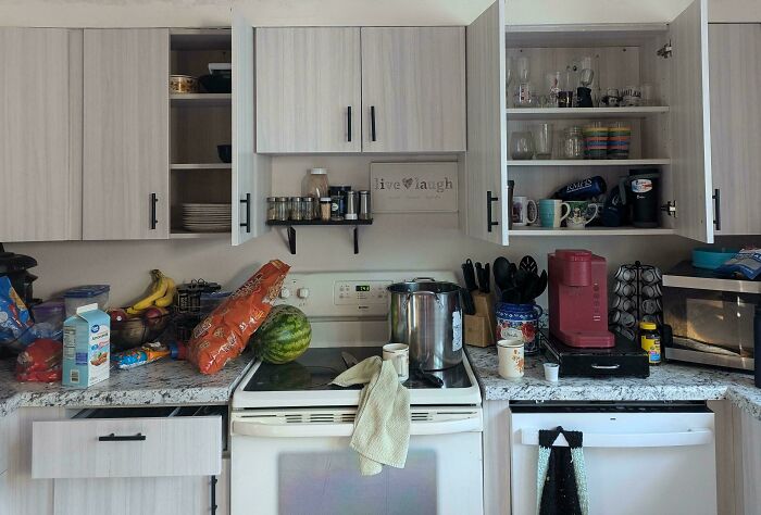 Messy kitchen with open cabinets and cluttered countertops, highlighting typical infuriating habits of boyfriends and husbands.