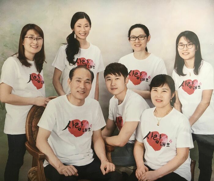 Family gathered together, smiling in matching shirts, conveying wholesome adoption stories and love.