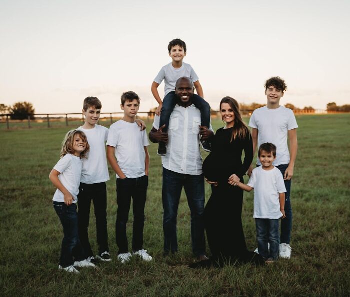 Family with children standing in a field, embodying wholesome adoption stories.